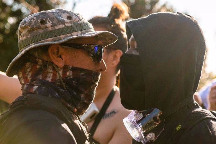 14 November 2020, US, Washington: A supporter of the USPresident Donald Trump and Black Lives Matter counterprotestor go face to face outside the Supreme Court during the 'Million Maga March' protest against the results of the 2020 presidential electio