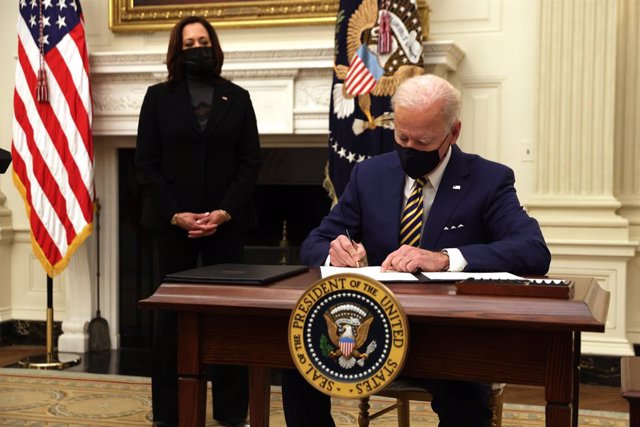 El presidente de Estados Unidos, Joe Biden, firma una orden ejecutiva ante la mirada de la vicepresidenta, Kamala Harris.