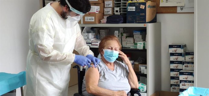 Un enfermero suministra la vacuna de la COVID-19 a una gran dependiente.