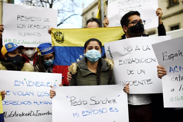 La mujer de Ernesto Quintero, el venezolano que fue detenido este miércoles por la Policía Nacional para ser extraditado a Venezuela, Cismary Marcano, sostiene una pancarta.