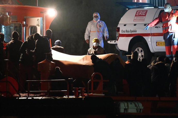 Trabajadores de Cruz Roja Española ayudan a un grupo de inmigrantes durante su llegada al Muelle de Gran Tarajal, Fuerteventura