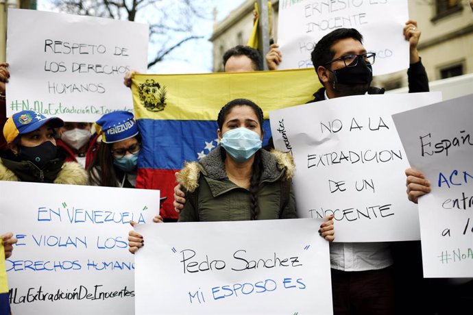 La mujer de Ernesto Quintero, el venezolano que fue detenido este miércoles por la Policía Nacional para ser extraditado a Venezuela, Cismary Marcano, sostiene una pancarta durante su visita al Tribunal Superior de Justicia Madrid para solicitar a las a