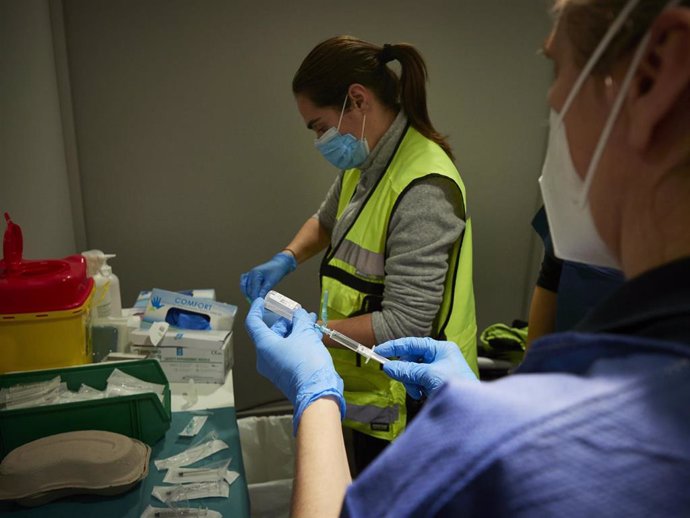 Dos trabajadoras sanitarias, en un dispositivo para administrar la vacuna contra la COVID-19 a profesionales sociosanitarios, en Pamplona, Navarra (España)