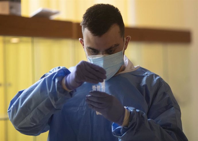 Un trabajador sanitario sostiene una probeta en un dispositivo de cribado masivo de antígenos organizado para detectar positivos por coronavirus en las instalaciones del Centro Cultural Los Pinos, en Alcorcón.