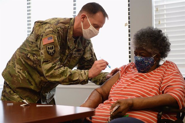 El sargento de la Guardia Nacional de Missouri, Herbert Lyns, administra una dosis de la vacuna contra el coronavirus a una anciana internada en una residencia de ancianos en la ciudad de Sant Louis.