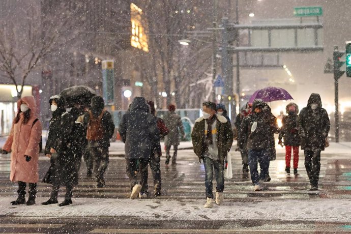03 February 2021, South Korea, Seoul: People walk on a street in central Seoul during the heavy snowfall. Photo: -/YNA/dpa