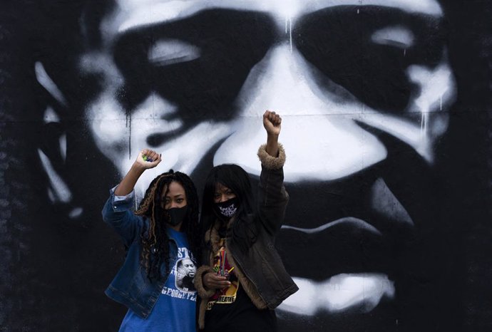 Dos mujeres alzan el puño con un mural de George Floyd a su espalda en la denominada 'Plaza George Floyd' de Mineaopolis, la ciudad donde el afroamericano fue asesinado por la Policía.
