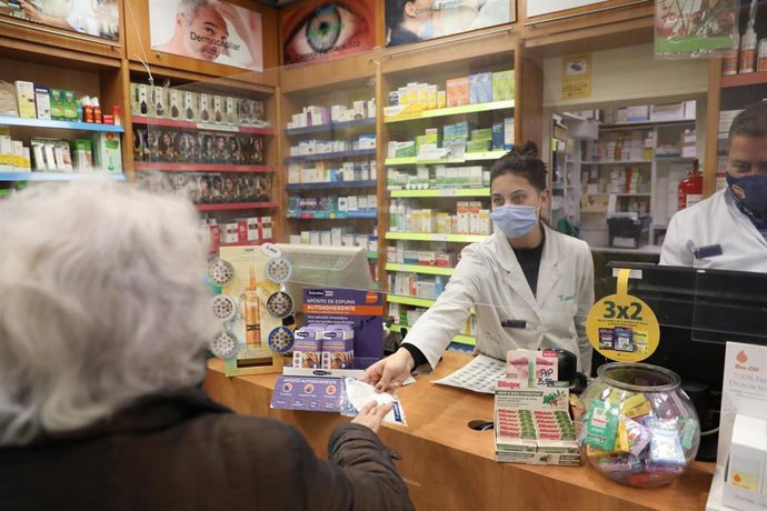 Una anciana recoge una mascarilla FFP2 en la farmacia situada en la C/Tucán (Carabanchel), en Madrid (España), a 4 de febrero de 2021. Los mayores de 65 años de la Comunidad de Madrid pueden recoger a partir de hoy la primera de las dos mascarillas FFP2