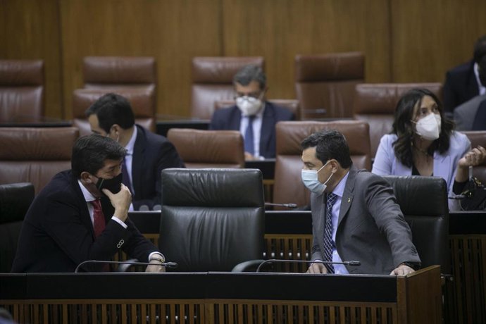El presidente de la Junta de Andalucía, Juanma Moreno (d), conversa con el vicepresidente de la Junta de Andalucía, Juan Marín (i), durante la primera jornada del Pleno del Parlamento de Andalucía. En Sevilla (Andalucía, España), a 10 de febrero de 2021.