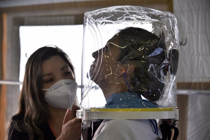 Una mujer utiliza un casco que permite prover oxígeno sin la necesidad de un respirador mecánico en un hospital de campaña instalado cerca del hospital de El Tunel en Bogotá durante al segunda ola.