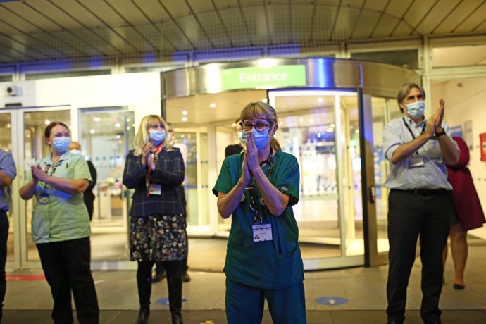 03 February 2021, United Kingdom, London: Doctors, nurses and NHS staff applaud outside the Chelsea and Westminster Hospital in London, as part of a nationwide clap in honour of Captain Sir Tom Moore, who died on Tuesday of Covid-19. The 100-year-old re