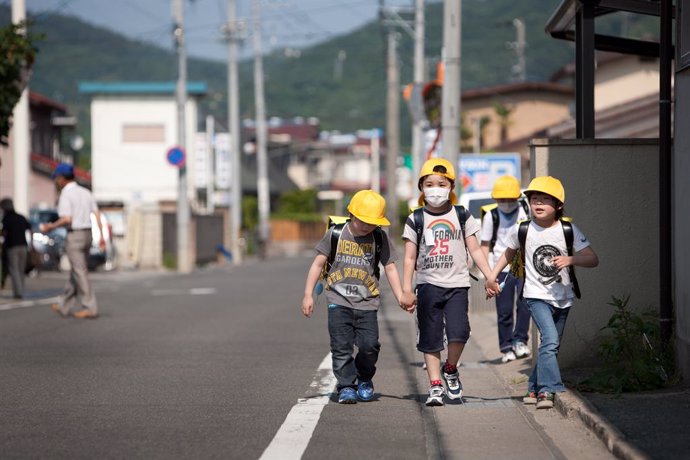 Children walk along a road which had earlier been assessed by a Greenpeace team for radioactive contamination. The team found the road to contain high, unsafe levels of contamination. The city of Fukushima has been contaminated by radioactive fallout fr