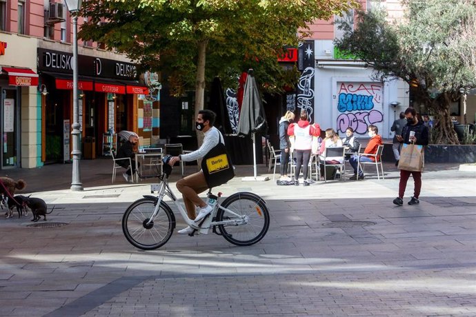 Un hombre pasea en bicicleta por la céntrica calle de Fuencarral, en Madrid (España) a 5 de octubre de 2020. Hoy es el primer día laborable desde que entraron en vigor -el viernes 2 de octubre a las 22.48h.- las restricciones de movilidad impuestas por 
