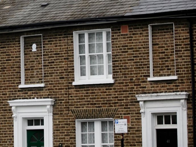 A Traditional terraced properties with modern apartment blocks behind in Greenwich on June 4, 2014 in London, England.