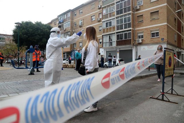 Sanitarios toman la temperatura a las personas citadas por Salud, antes de  hacerse los test rápidos de antígenos PCR, en un cribado masivo en la barriada malagueña de La Luz. 