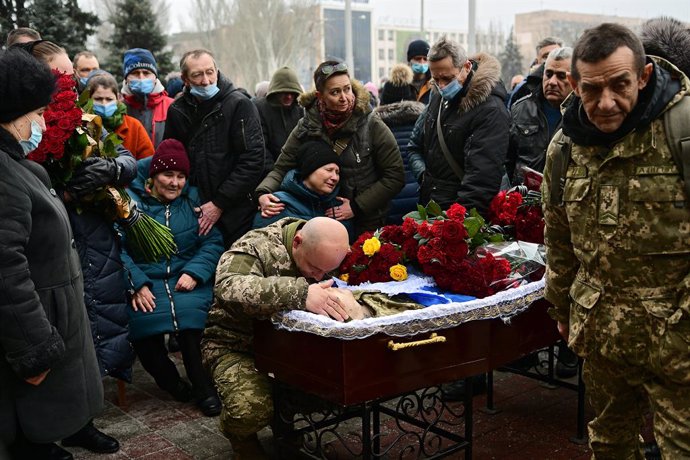 14 January 2021, Ukraine, Zaporizhzhia: People pay their respects to perished soldier Oleh Andriienko during his funeral ceremony outside the Zaporizhzhia Regional State Administration. The 37-year-old serviceman was shot dead by a sniper near the Pisky