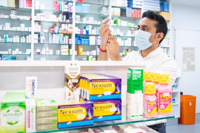 28 January 2021, United Kingdom, London: Pharmacist Bhaveen Patel draws up a dose of the Oxford/AstraZeneca COVID-19 vaccine in preparation for coronavirus vaccinations during a clinic held at Junction Pharmacy. The roll out of the vaccination programme