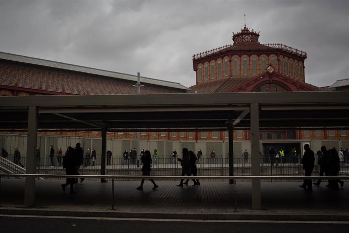 Varias personas hacen cola a las afueras del Polideportivo Tres Xemeneies en Barcelona, Cataluña (España), a 14 de febrero de 2021. La jornada electoral transcurre con protocolos de seguridad ante el Covid-19 y franjas horarias: de 9 a 12 horas, para co