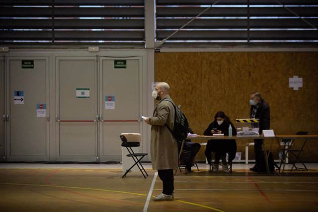Un hombre espera para votar en una mesa electoral del Polideportivo Tres Xemeneies, en Barcelona, Cataluña (España), a 14 de febrero de 2021