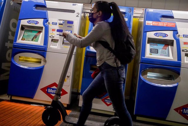 Una mujer entra con un patinete eléctrico en el metro de Ciudad Lineal