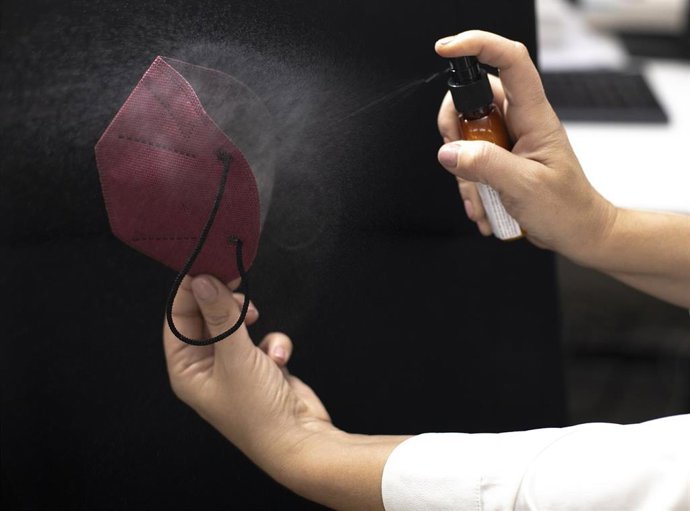 Una trabajadora tiñe de color burdeos una mascarilla FFPP2 en la fábrica de Airnatech Antiviral, en Castellón de la Plana, Comunidad Valenciana (España), a 10 de febrero de 2021. 