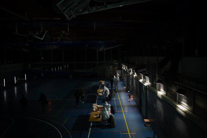 Miembros de las mesas se quitan los Equipos de Protección Individual (EPI) después de la franja horaria en la que han acudido los electores contagiados, contactos estrechos y sospechosos de ser positivos para votar en las elecciones de Cataluña de 2021,