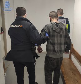 Un agente de la Policía Nacional con el detenido.