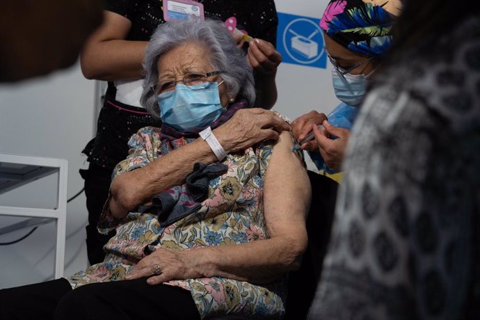 03 February 2021, Chile, Santiago: Leonila Gonzalez, 96, receives a dose of the Sinovac Coronavirus vaccine by a health personnel on the first day of mass vaccination, at a vaccination centre mounted at the Bicentenario Stadium. Photo: Matias Basualdo/Z