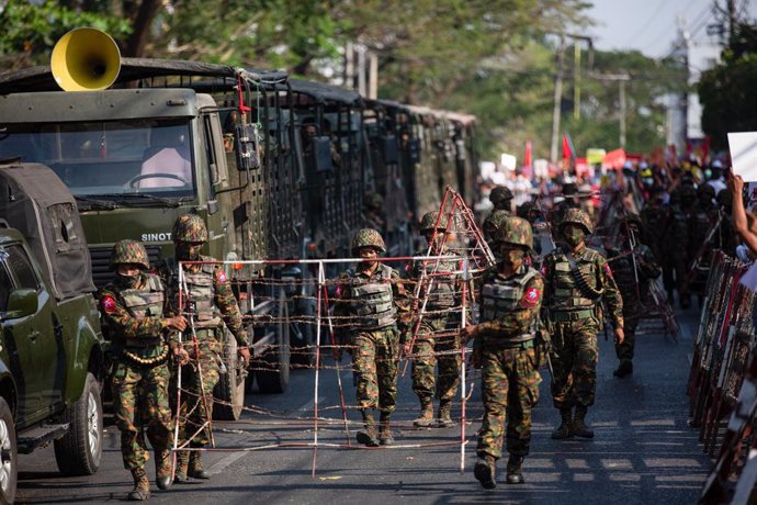 15 February 2021, Myanmar, Yangon: Soldiers carry barricades along the streets leading to the Central Bank of Myanmar during a protest against the military coup. Photo: Aung Kyaw Htet/SOPA Images via ZUMA Wire/dpa