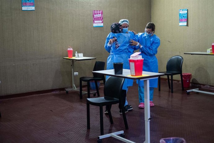 Enfermeras se abrazan en medio de la vacunación contra el coronavirus.