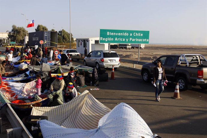 25 June 2019, Chile, Arica: Migrants from Venezuela lie on the ground in front of a border checkpoint, waiting for the visa to enter Chile. Photo: Alexander Infante/Agencia Uno/dpa
