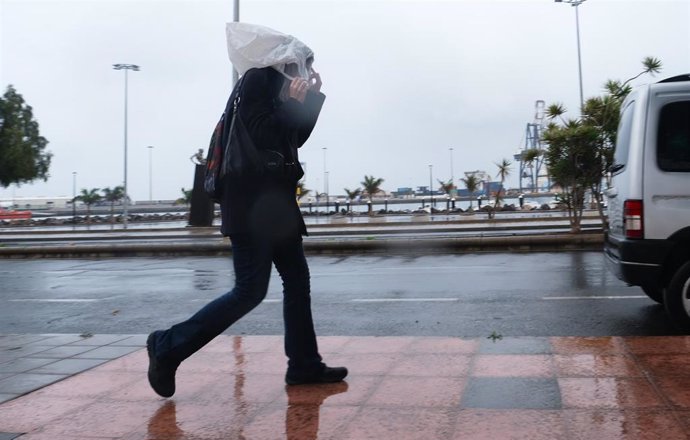 Una persona camina con una bolsa en la cabeza por las fuertes lluvias