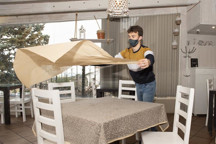 Un camarero trabaja en el interior de un bar en el casco histórico de Cuenca.