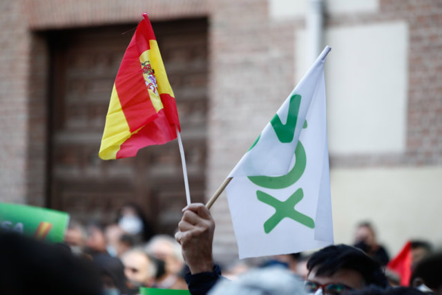 Una persona sostiene una bandera de España y otra de Vox durante una concentración en defensa de la Carta Magna y contra el Gobierno de Pedro Sánchez, en la Plaza de la Villa, en Madrid (España), a 6 de diciembre de 2020.