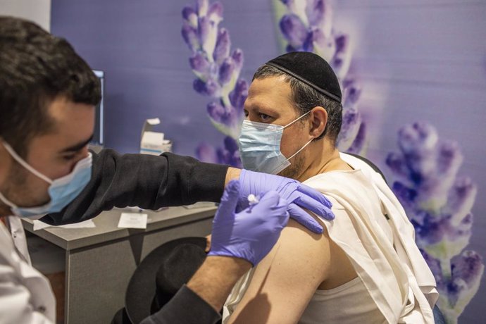 11 January 2021, Israel, Jerusalem: An Orthodox Jewish man receives his dose of the Pfizer-BioNTech COVID-19 vaccine at a vaccination centre as a part of a nationwide campaign. Israeli Health Minister Yuli Edelstein earlier said that Israel has vaccinat