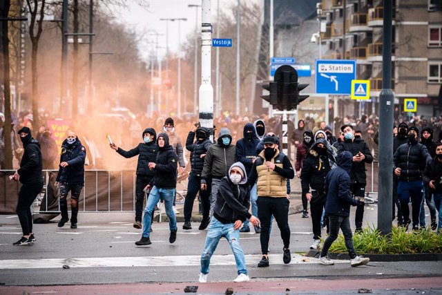 24 January 2021, Netherlands, Eindhoven: Demonstrators throw stones towards the police during a demonstration against the current Corona policy in front of the Eindhoven Railway station. Photo: Rob Engelaar/ANP/dpa