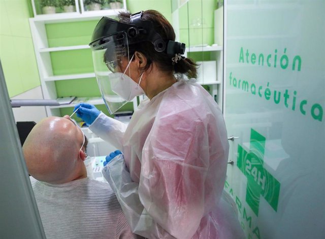 La farmacéutica Begoña realiza un test de antígeno a un hombre en la farmacia Las Gemelas.