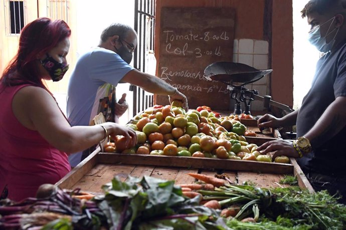 Varias personas compran en una frutería en La Habana.