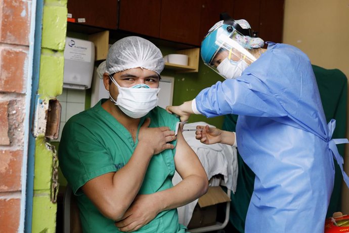 09 February 2021, Peru, Lima: A health worker receives a dose of the Sinopharm coronavirus (COVID-19) vaccine at San Bartolome National Hospital. Photo: Mariana Bazo/ZUMA Wire/dpa