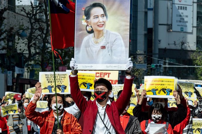 14 February 2021, Japan, Tokyo: Protesters hold placards and a photo of  Myanmar State Counsellor Aung San Suu during a demonstration against the military coup d'etat that deposed Myanmar State Counsellor Aung San Suu Kyi. Photo: Viola Kam/SOPA Images v