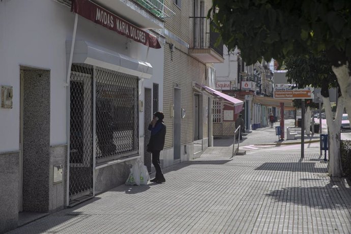 Una mujer observa el escaparate de una tienda de ropa cerrada.