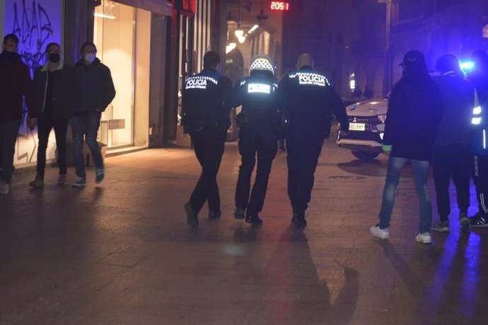 Dos agentes de la Policía Local de Lleida trasladan al edificio del Ayuntamiento a un compañero herido este martes.
