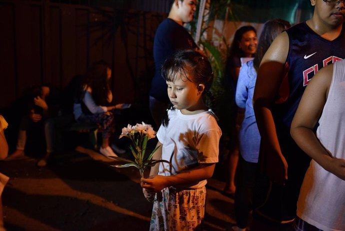 Archivo - Una niña sujeta un ramo de flores en la cudad de Davao en Filipinas