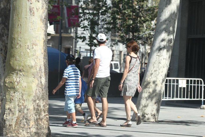 Archivo - Un hombre y una mujer pasean por la calle con un niño.