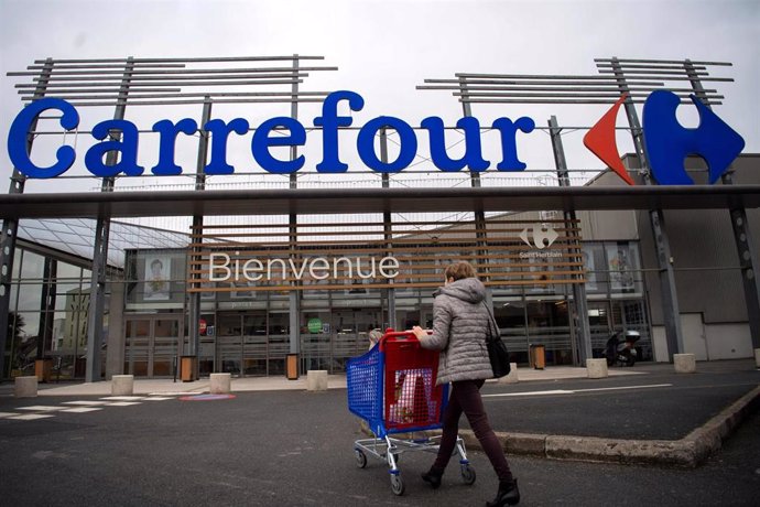Archivo - 13 January 2021, France, Saint-Herblain: A woman enters a French retail supermarket Carrefour. A visitor enters a supermarket of the French retail group Carrefour. Europe's largest retail group Carrefour has been targeted by its Canadian compe