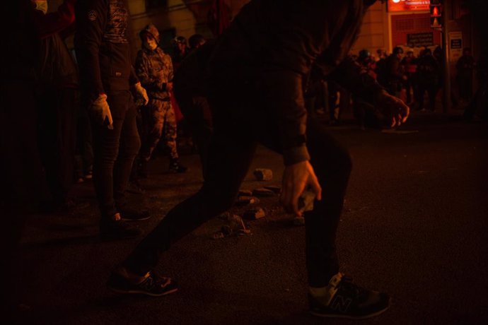 Encaputxats llancen pedres i cremen contenidors en la tercera nit de disturbis a Barcelona en protesta per l'empresonament de Pablo Hasel, el 18 de febrer de 2021.