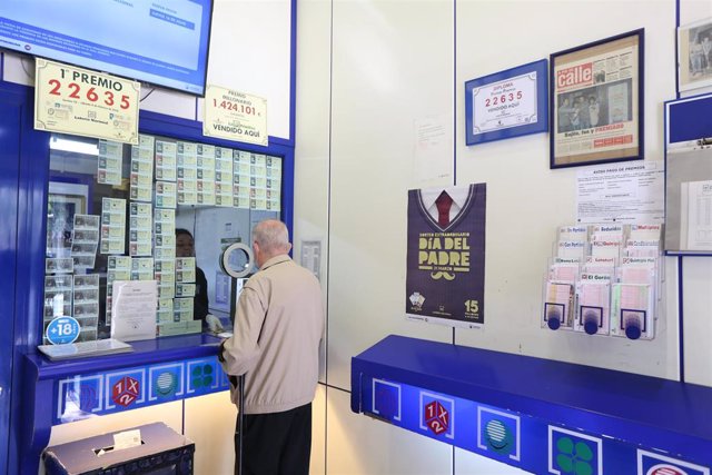 Archivo - Un hombre compra lotería en una Administración de Lotería en una imagen de archivo