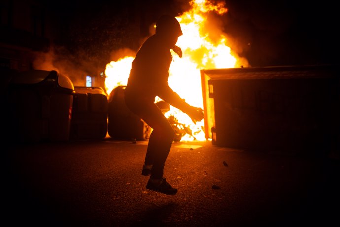 Manifestantes queman contenedores durante una manifestación contra el encarcelamiento del rapero y poeta Pablo Hasel en Barcelona (España), a 18 de febrero de 2021. 