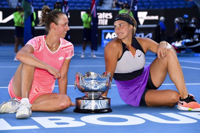Elise Mertens of Belgium (left) and Aryna Sabalenka of Belarus pose for photographs with the trophy after winning their Women's Doubles Finals match against Barbora Krejcikova of the Czech Republic and Katerina Siniakova of the Czech Republic on Day 12 