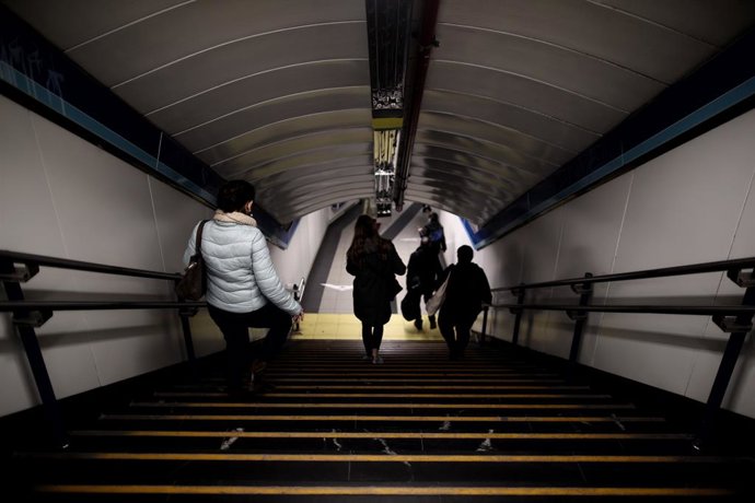 Varios pasajeros se dirigen a un andén de Metro de Madrid.